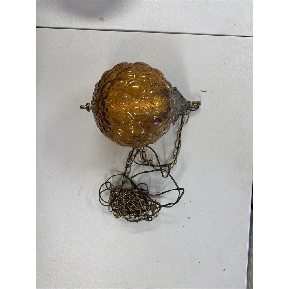 vintage mid-century modern hanging lamp features a distinctive amber glass globe